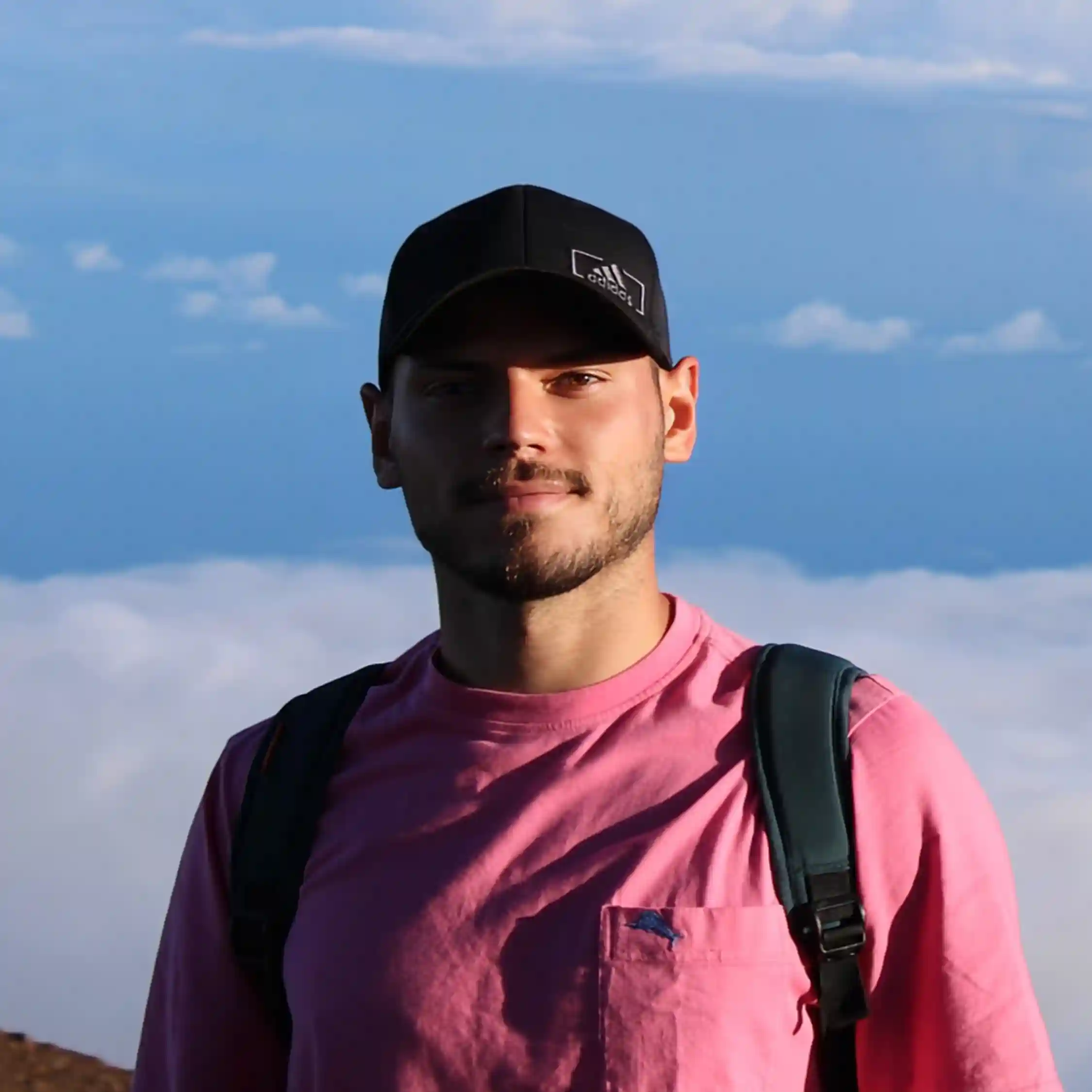 Emiliano Bregains. He is in a mountain, above the clouds. the background is only sky.